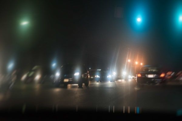 Unscharfe Autoscheinwerfer und farbige Lichtquellen bei einer Nachtfahrt